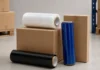 Clear, blue and black hand stretch film rolls with corrugated shipping boxes