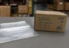 Clear 2 mil reclosable poly bags beside their corrugated product case